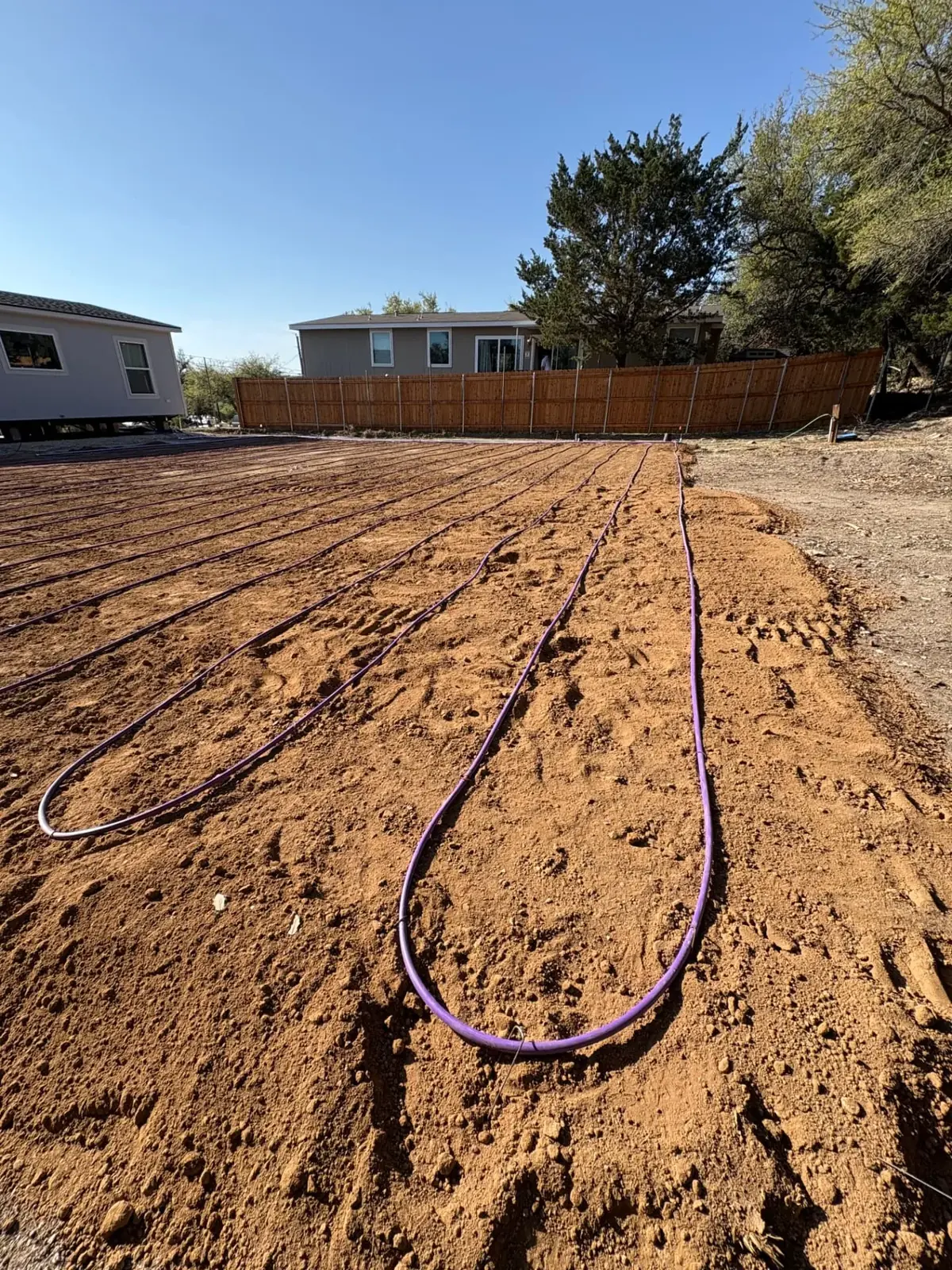 Purple drip irrigation tubing laid across a prepared dispersal field